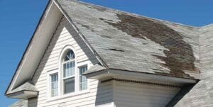 home in need of a roof replacement after getting hit from severe heavy winds